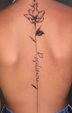 a woman's back with a flower tattoo on it