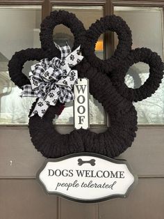 a dog's welcome sign is attached to the front door of a house with a large pair of scissors on it