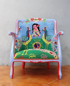 a blue chair with an image of a woman on the back and two birds painted on it