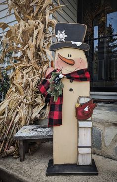 a wooden snowman with a hat and scarf