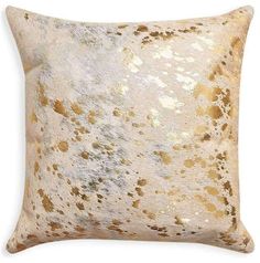 a gold and white pillow with spots on it's side, in front of a white background