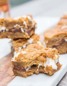 chocolate chip cookie bars with marshmallows cut in half on a cutting board