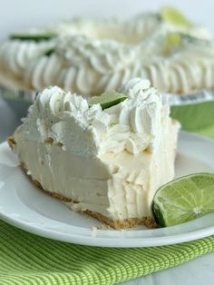 a slice of key lime pie on a white plate with a lime wedge next to it