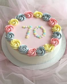 a white cake with pink, yellow and blue frosting