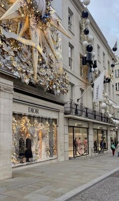 a street scene with people walking on the sidewalk and christmas decorations hanging from the buildings