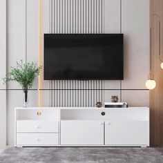 an entertainment center with a flat screen tv mounted on the wall and two white drawers