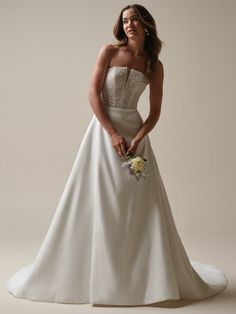 a woman in a wedding dress posing for the camera with her hands on her hips