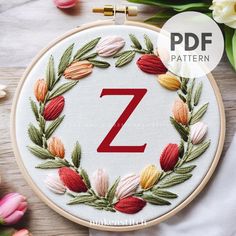 the letter z is surrounded by flowers and leaves on a white background with text overlay