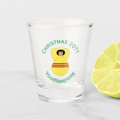 a shot glass next to a lemon on a white surface with the words christmas 2013 yournameme here