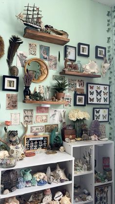 a room filled with lots of different types of items and pictures on the wall next to bookshelves