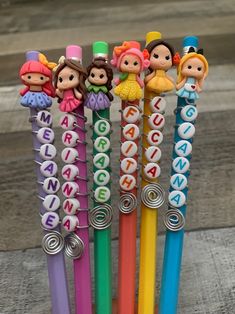 several different colored pens with little cartoon characters on them, all lined up in the same row