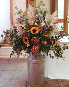 a vase filled with lots of flowers on top of a table