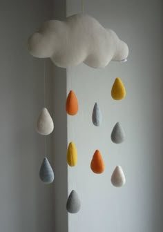 a cloud mobile with raindrops hanging from it's sides in a white room