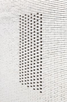 a white brick wall with holes in it