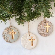 three ceramic ornaments hanging from a christmas tree