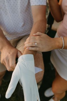 a man and woman holding hands while sitting on the ground