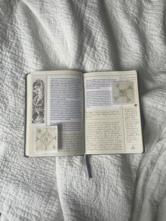 an open book laying on top of a bed