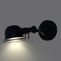 a black wall light with a dimmer on it's side and the bulb turned off