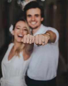 a man and woman are pointing their fingers at the camera