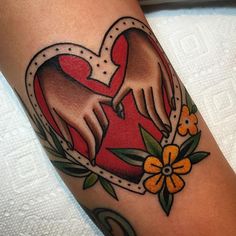 a tattoo on someone's arm with a heart and flowers