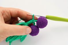 someone is crocheting two small balls of yarn to make an ornament