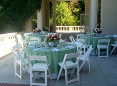 an outdoor dining area with tables and chairs set up for a formal function in the shade