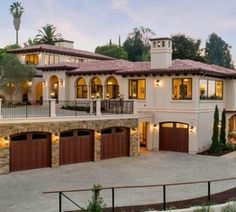 a large house with lots of windows and garage doors on the front side of it