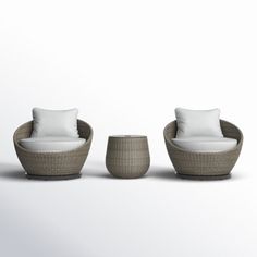 three wicker chairs with white pillows and two small stools on the floor next to each other