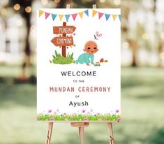 a welcome sign with a baby on it in front of some grass and trees,