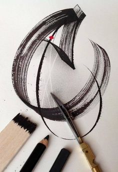 the scissors are next to some different types of pencils and ink on white paper