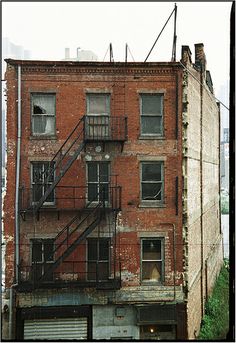 an old brick building with fire escape stairs on the top and second story above it