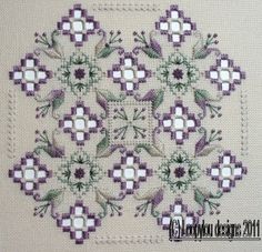 a cross stitch pattern with purple and white flowers