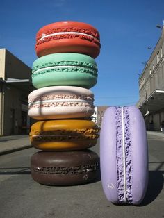 a stack of doughnuts sitting on top of each other in front of a building