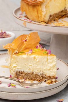 a slice of cheesecake on a plate with a fork next to the rest of the cake