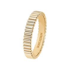 a yellow gold ring with wavy lines on the outside, and a thin band that has been