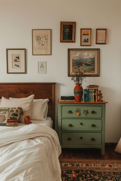 a bedroom with a bed, dresser and pictures on the wall