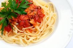 pasta with tomato sauce and parsley in a white bowl