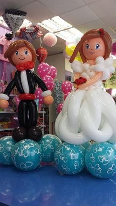 balloons are arranged in the shape of bride and grooms on top of blue balls