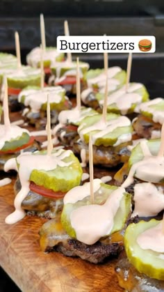 small appetizers with toothpicks are on a cutting board and drizzled with white sauce