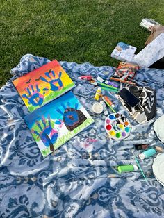 art supplies laid out on a blanket in the grass