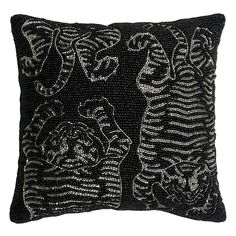 a black and white pillow with an intricate design on the front, featuring two cats