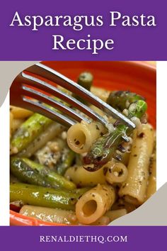 a plate with pasta, asparagus and other vegetables on it that is being eaten by a fork