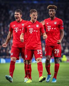 three soccer players in red uniforms standing on the field with their mouths open and hands together