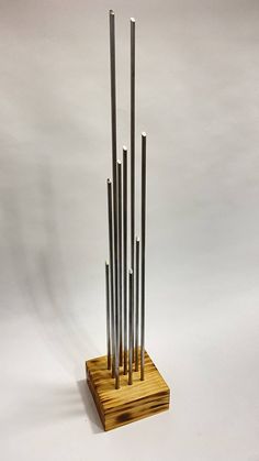 a wooden stand with four metal rods on it's sides and one standing upright