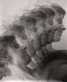 a black and white photo of four people with their faces obscured by the image's shadow