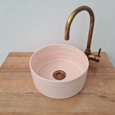 a sink with a faucet on top of it and a wooden countertop