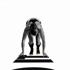 a man is standing on one leg with his hands in the air while doing push ups