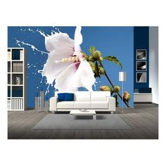 a living room with a white couch and large flower on it's back wall