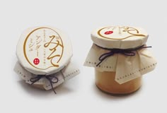 two jars filled with honey sitting next to each other on top of a white surface