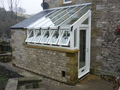 a brick building with a white glass roof and windows on the side of it's wall